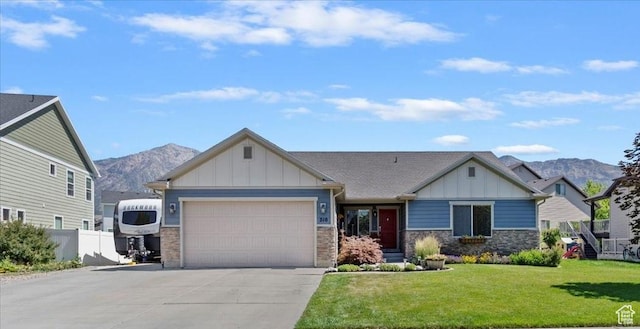 210 E 2150 N, North Ogden, UT 84414 - craftsman-style house with driveway, board and batten siding, a mountain view, an attached garage, and a front lawn