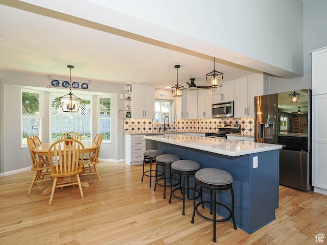 1402 E Valley Ridge Dr S, Sandy, UT 84093 - kitchen featuring appliances with stainless steel finishes, a center island, white cabinets, a kitchen bar, and open shelves