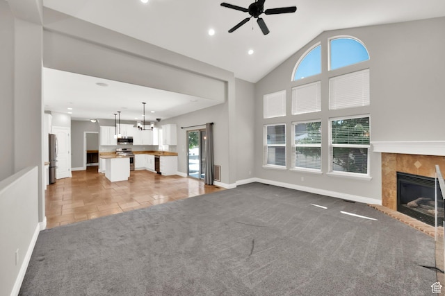 3179 W Hayden Ridge Way S, Riverton, UT 84065 - unfurnished living room with a ceiling fan, recessed lighting, a tiled fireplace, light colored carpet, and a chandelier