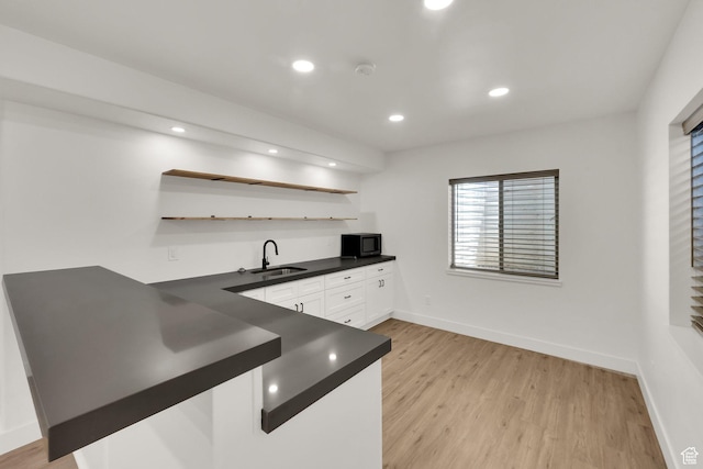 3179 W Hayden Ridge Way S, Riverton, UT 84065 - kitchen with black microwave, dark countertops, open shelves, white cabinetry, and light wood finished floors