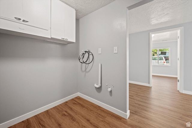 1302 E Harrop S, Ogden, UT 84404 - washroom featuring cabinet space, hookup for a washing machine, light wood-style flooring, a textured ceiling, and hookup for a gas dryer
