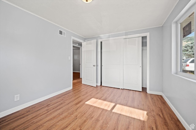 1302 E Harrop S, Ogden, UT 84404 - unfurnished bedroom featuring crown molding, wood finished floors, and a closet
