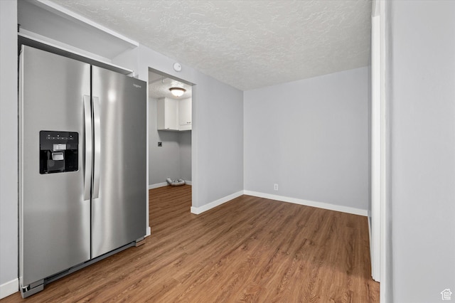 1302 E Harrop S, Ogden, UT 84404 - kitchen featuring stainless steel fridge with ice dispenser, a textured ceiling, light wood-type flooring, and white cabinetry