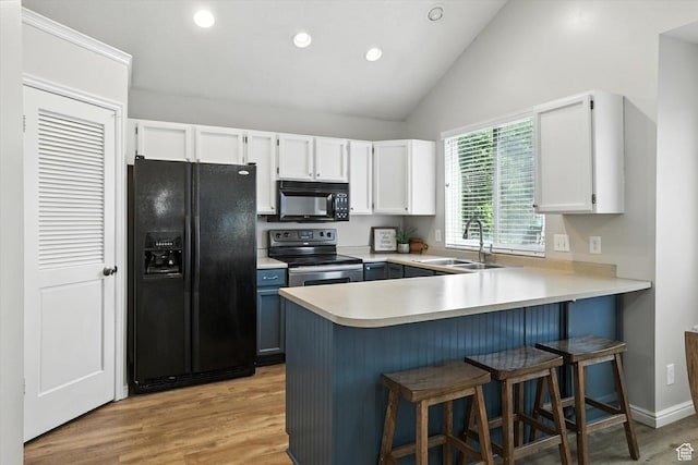 433 W 2425 N, Harrisville, UT 84414 - kitchen featuring black appliances, a peninsula, white cabinets, light countertops, and a breakfast bar area