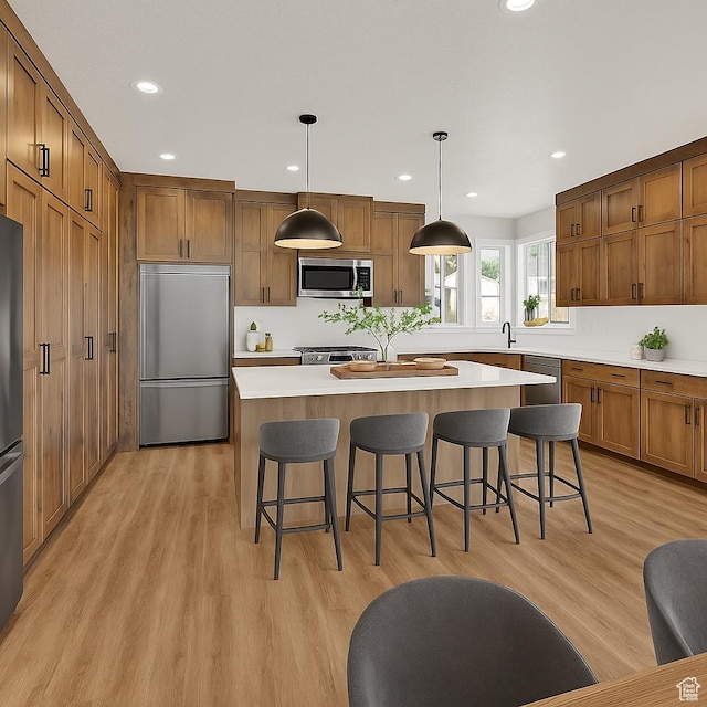 3636 N 500 E, North Ogden, UT 84414 - kitchen with stainless steel appliances, a kitchen island, brown cabinets, light countertops, and light wood finished floors
