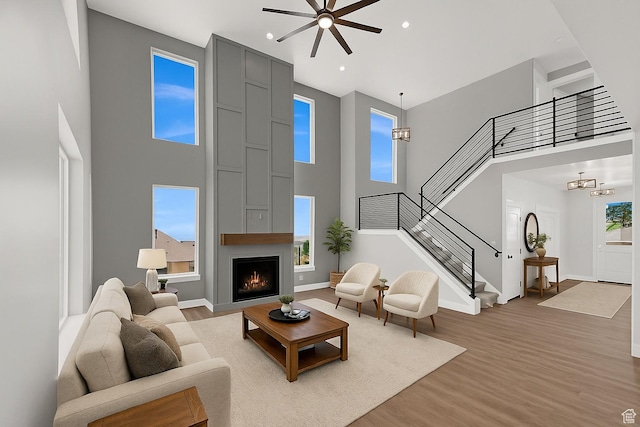 3636 N 500 E, North Ogden, UT 84414 - living room featuring a high ceiling, light wood-style flooring, stairs, a large fireplace, and a ceiling fan