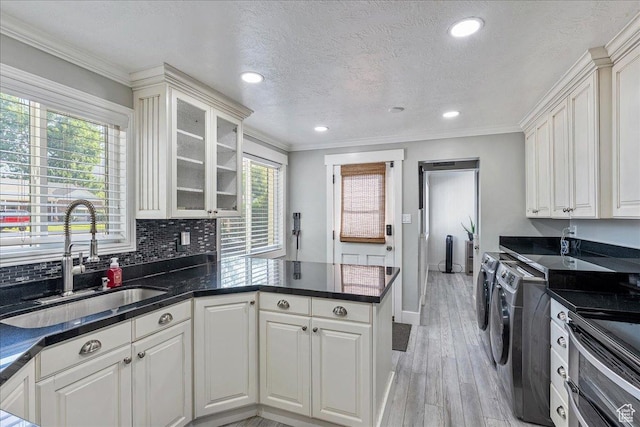 104 E 650 N, Bountiful, UT 84010 - kitchen featuring washing machine and dryer, a peninsula, light wood-style flooring, white cabinets, and crown molding