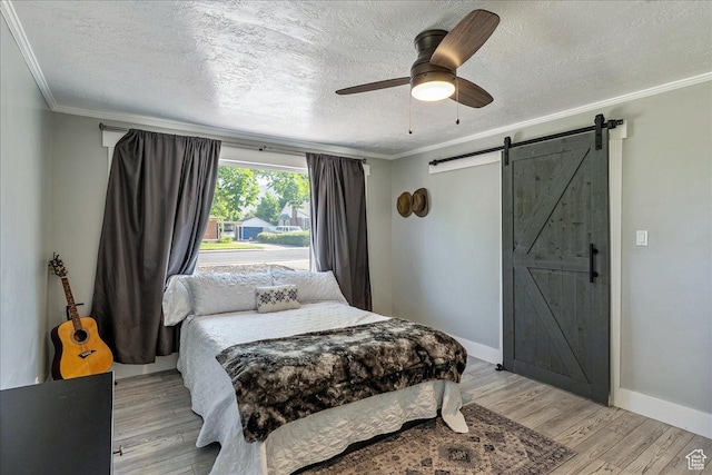 104 E 650 N, Bountiful, UT 84010 - bedroom featuring crown molding, a barn door, a textured ceiling, light wood-style floors, and ceiling fan