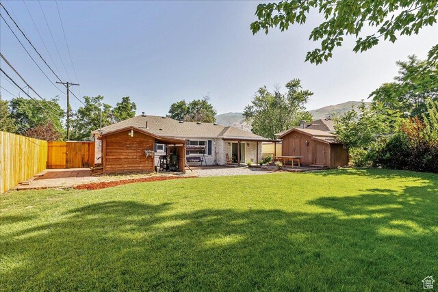 104 E 650 N, Bountiful, UT 84010 - back of property featuring a storage shed, a fenced backyard, a patio area, and a mountain view