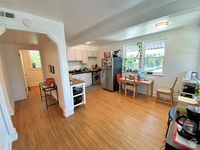 1309 E Hidden Creek Ct S, Holladay, UT 84117 - kitchen featuring freestanding refrigerator, white cabinets, plenty of natural light, and light wood-type flooring