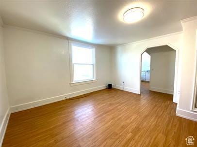 1309 E Hidden Creek Ct S, Holladay, UT 84117 - spare room with arched walkways, ornamental molding, and wood finished floors