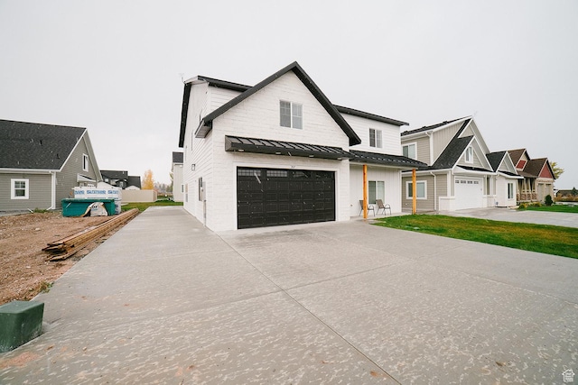 357 W Posies Dr, Garden City, UT 84028 - modern farmhouse style home with a standing seam roof, concrete driveway, an attached garage, and a metal roof