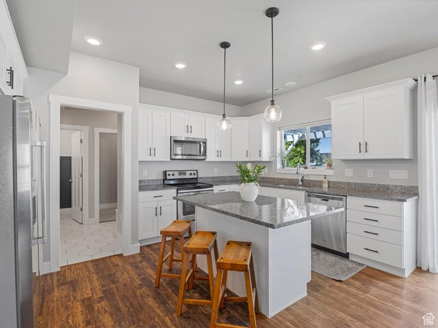3187 N 3450 W, Plain City, UT 84404 - kitchen with stainless steel appliances, a breakfast bar area, white cabinets, and recessed lighting