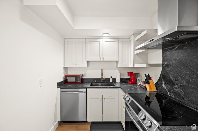 1492 Meadow Rd, Snyderville, UT 84098 - kitchen with stainless steel appliances, wall chimney range hood, white cabinetry, dark countertops, and open shelves