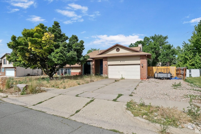 632 S 1150 W, Layton, UT 84041 - view of front facade with brick siding, a garage, concrete driveway, and a chimney