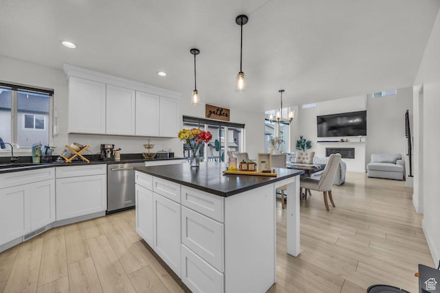 12357 S Eovaldi Ave, Herriman, UT 84096 - kitchen featuring stainless steel dishwasher, dark countertops, a chandelier, white cabinets, and light wood-style floors