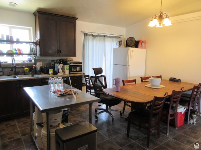 544 E 1875 S, Roosevelt, UT 84066 - kitchen featuring freestanding refrigerator, dark brown cabinetry, a chandelier, and pendant lighting