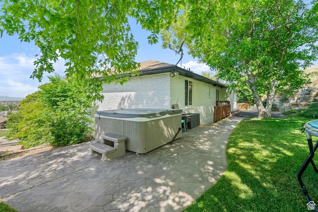 958 N Main St W, Farmington, UT 84025 - view of side of home with a hot tub, a patio area, brick siding, and a lawn