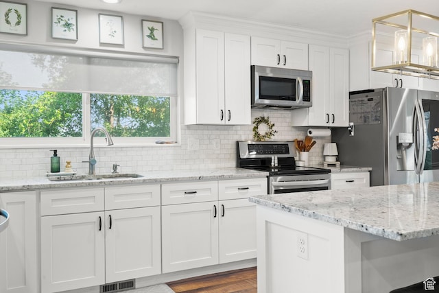 958 N Main St W, Farmington, UT 84025 - kitchen with stainless steel appliances, white cabinetry, decorative backsplash, and light stone counters