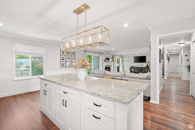 958 N Main St W, Farmington, UT 84025 - kitchen featuring a warm lit fireplace, dark wood-type flooring, light stone counters, recessed lighting, and a center island