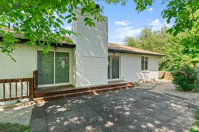 958 N Main St W, Farmington, UT 84025 - back of house with a chimney, brick siding, a patio area, and a wooden deck