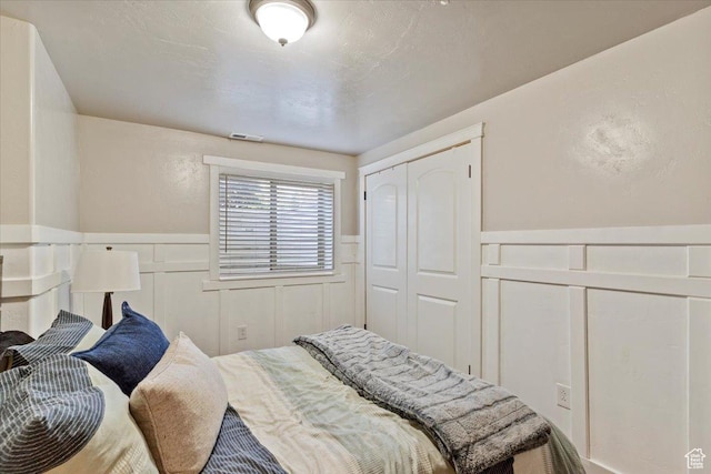 2876 S 1200 W, Syracuse, UT 84075 - bedroom featuring a decorative wall, wainscoting, and a closet