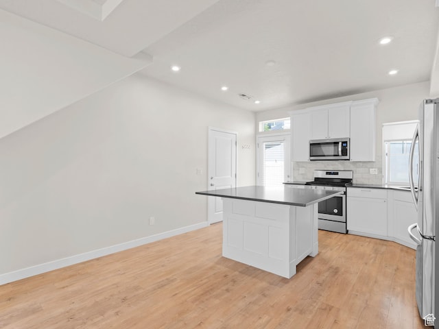 3199 W 2450 N, Lehi, UT 84043 - kitchen with appliances with stainless steel finishes, dark countertops, decorative backsplash, light wood finished floors, and a center island