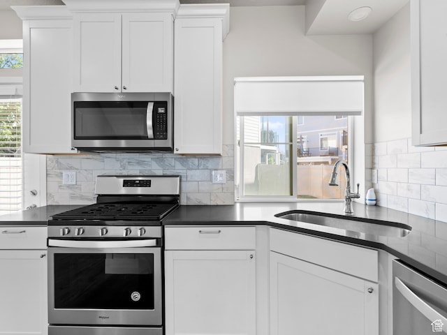 3199 W 2450 N, Lehi, UT 84043 - kitchen featuring appliances with stainless steel finishes, dark countertops, white cabinetry, and decorative backsplash