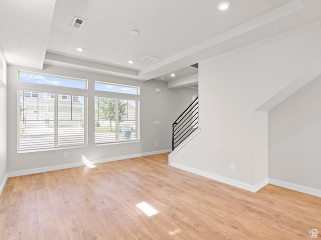 3199 W 2450 N, Lehi, UT 84043 - unfurnished living room with stairs, light wood finished floors, a tray ceiling, and recessed lighting