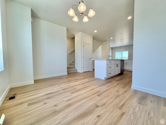 1650 N Main St N Unit 116, Layton, UT 84041 - unfurnished living room featuring a chandelier, a textured ceiling, light wood-style floors, stairs, and recessed lighting
