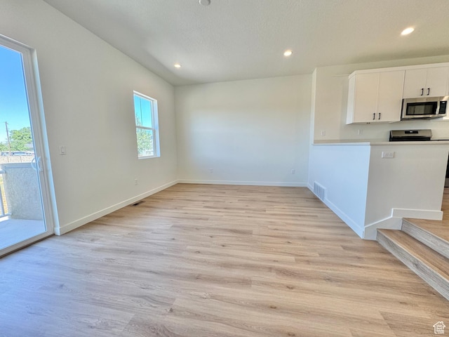 1650 N Main St N Unit 116, Layton, UT 84041 - unfurnished dining area featuring recessed lighting, light wood-style floors, and stairway