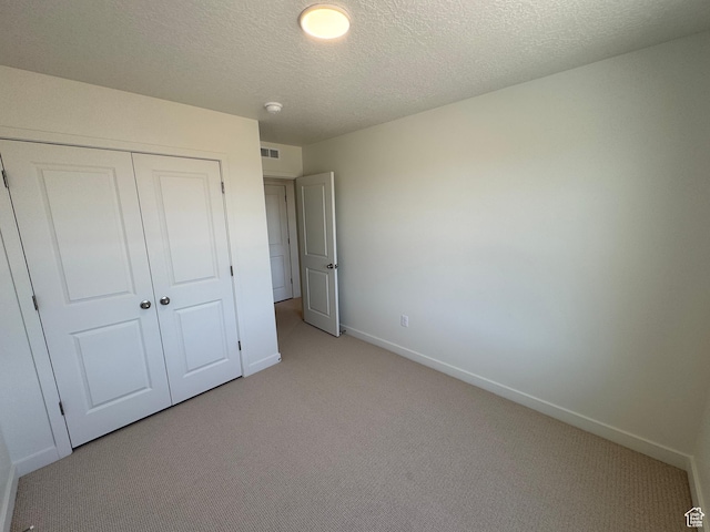 1650 N Main St N Unit 116, Layton, UT 84041 - unfurnished bedroom featuring light carpet, a closet, and a textured ceiling