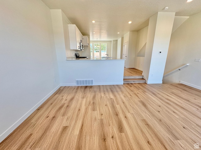 1650 N Main St N Unit 116, Layton, UT 84041 - unfurnished living room with light wood finished floors and recessed lighting