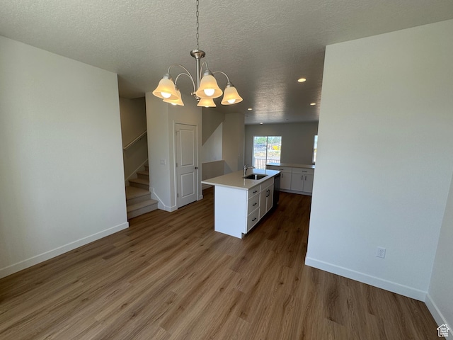 1650 N Main St N Unit 116, Layton, UT 84041 - kitchen with white cabinetry, light countertops, a chandelier, wood finished floors, and a textured ceiling