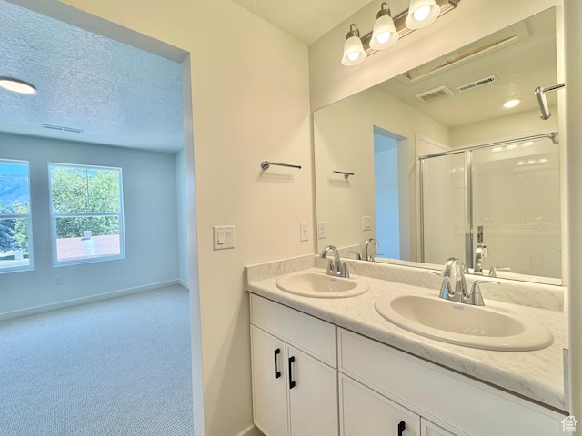 1650 N Main St N Unit 116, Layton, UT 84041 - bathroom featuring a stall shower, double vanity, and a textured ceiling
