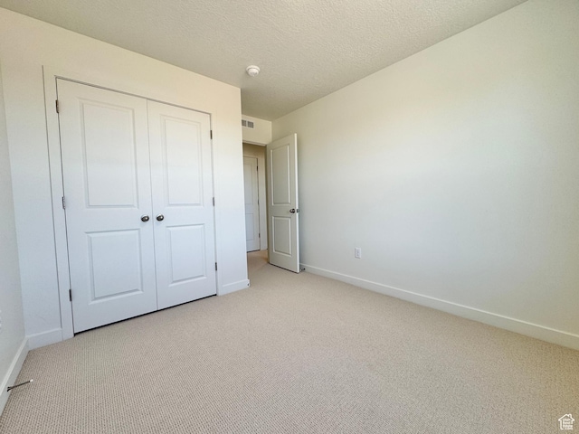 1650 N Main St N Unit 116, Layton, UT 84041 - unfurnished bedroom with light carpet, a closet, and a textured ceiling