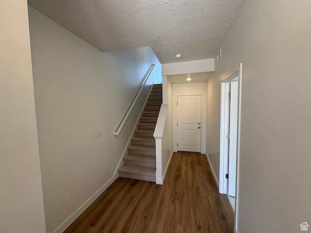 1650 N Main St N Unit 116, Layton, UT 84041 - stairs with wood finished floors, a textured ceiling, and recessed lighting