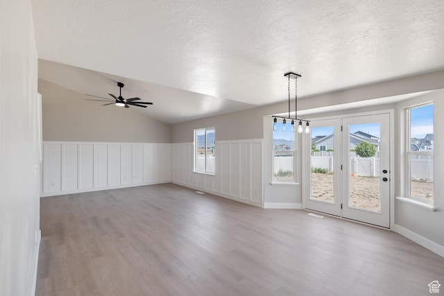 1919 E Church Way, Eagle Mountain, UT 84005 - unfurnished dining area with light wood-type flooring, a textured ceiling, a ceiling fan, wainscoting, and vaulted ceiling