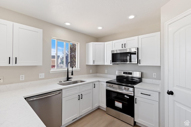 1919 E Church Way, Eagle Mountain, UT 84005 - kitchen featuring stainless steel appliances, white cabinets, recessed lighting, light countertops, and light wood-type flooring