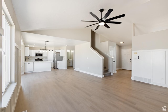 1919 E Church Way, Eagle Mountain, UT 84005 - unfurnished living room featuring high vaulted ceiling, a ceiling fan, stairs, light wood-type flooring, and recessed lighting