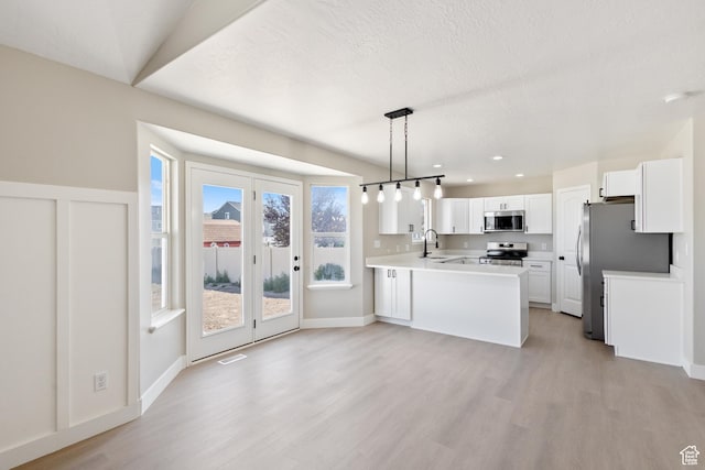 1919 E Church Way, Eagle Mountain, UT 84005 - kitchen featuring stainless steel appliances, light wood-style floors, a peninsula, white cabinetry, and recessed lighting