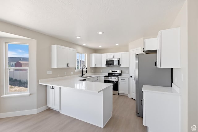 1919 E Church Way, Eagle Mountain, UT 84005 - kitchen with stainless steel appliances, light wood-style flooring, a peninsula, light countertops, and recessed lighting