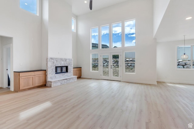 7625 N Silver Creek Way, Eagle Mountain, UT 84005 - unfurnished living room featuring a towering ceiling, ceiling fan, a stone fireplace, light wood-style floors, and recessed lighting