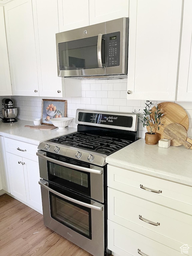 920 S 940 W, Richfield, UT 84701 - kitchen featuring stainless steel appliances, white cabinets, tasteful backsplash, and light wood-style floors