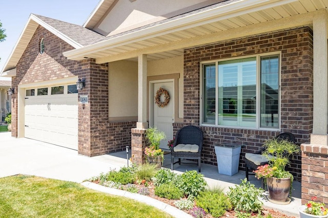 1065 W 2740 S, Nibley, UT 84321 - doorway to property featuring brick siding, an attached garage, concrete driveway, covered porch, and a shingled roof