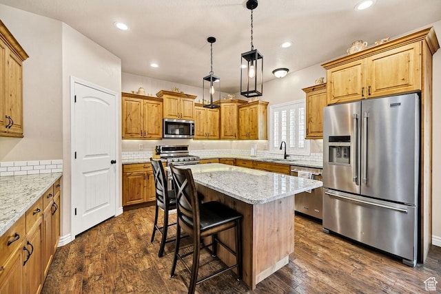 1065 W 2740 S, Nibley, UT 84321 - kitchen with stainless steel appliances, dark wood-type flooring, a kitchen island, light stone counters, and recessed lighting
