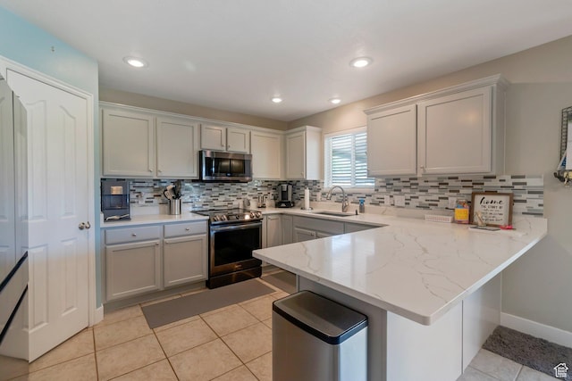 2714 E Stony Hill Way S, Spanish Fork, UT 84660 - kitchen featuring appliances with stainless steel finishes, a peninsula, decorative backsplash, light tile patterned flooring, and light stone counters
