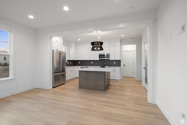 6658 W Docksider Dr, South Jordan, UT 84009 - kitchen with appliances with stainless steel finishes, backsplash, white cabinetry, light countertops, and a center island