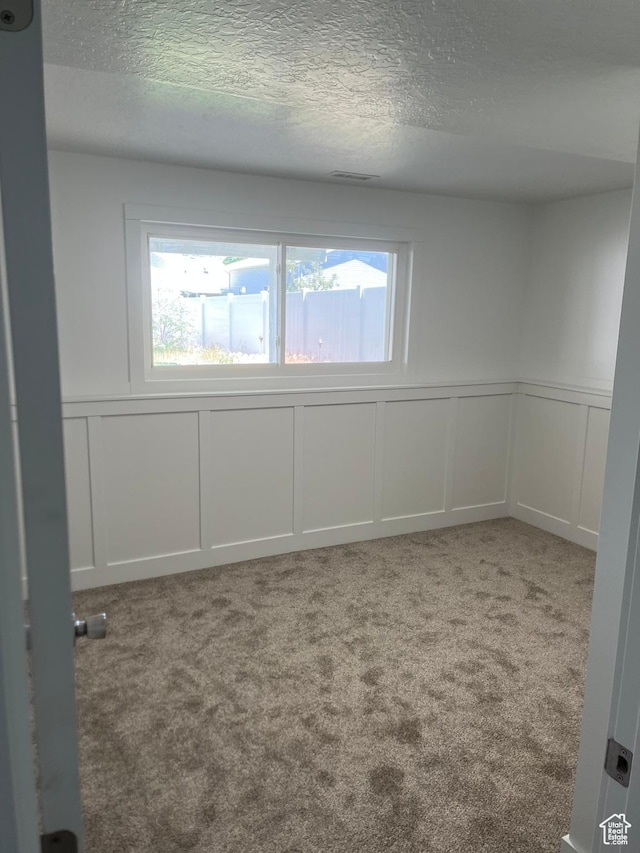 390 W 5050 S, Washington Terrace, UT 84405 - carpeted spare room featuring a decorative wall, a textured ceiling, and a wainscoted wall