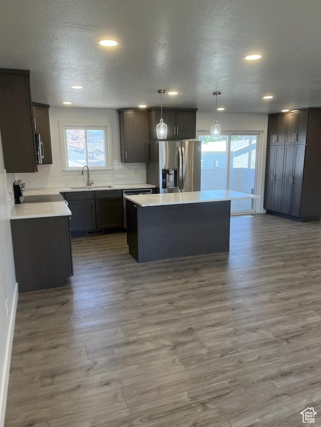390 W 5050 S, Washington Terrace, UT 84405 - kitchen with stainless steel appliances, plenty of natural light, a center island, wood finished floors, and a textured ceiling